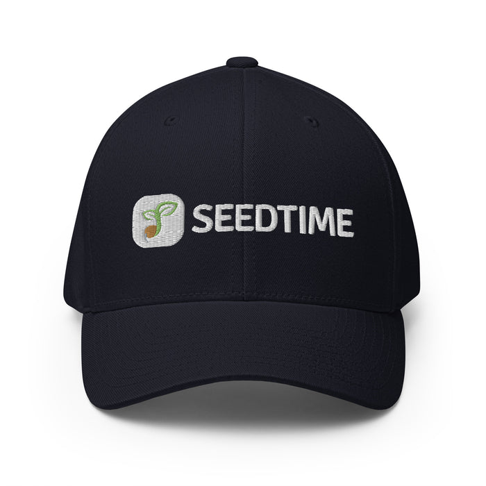 Navy blue fitted baseball cap with embroidered Seedtime logo: green sprout icon and white "SEEDTIME" text.