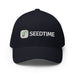 Navy blue fitted baseball cap with embroidered Seedtime logo: green sprout icon and white "SEEDTIME" text.