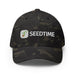 Dark camo Seedtime baseball cap with embroidered white logo and green sprout design.
