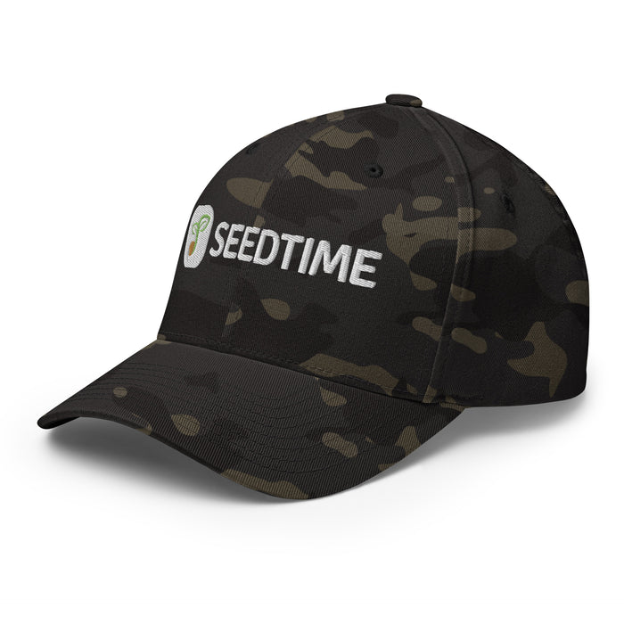 Dark camouflage baseball cap with white embroidered Seedtime logo featuring a green sprouting seed.