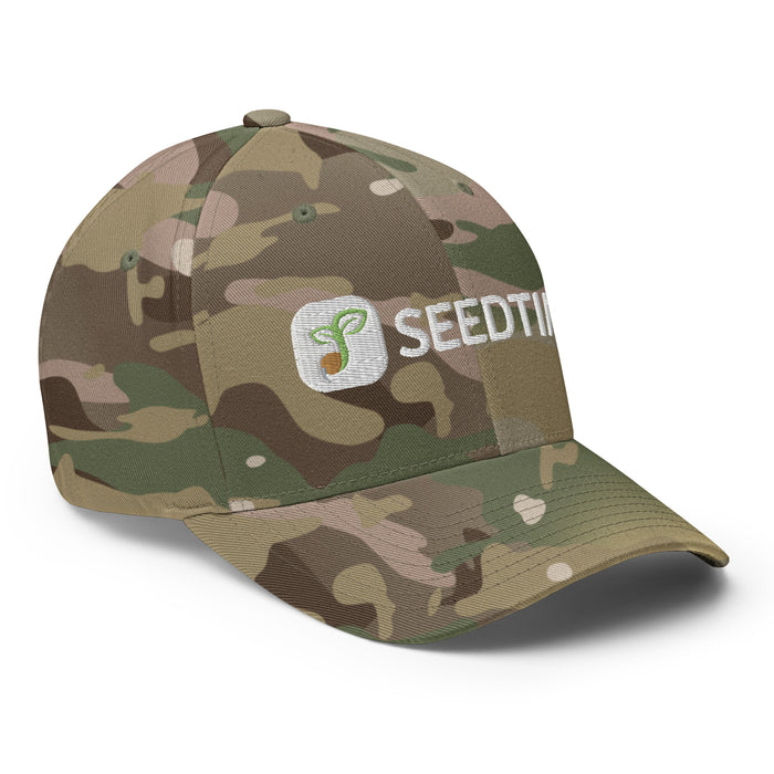 Multicam camouflage baseball cap with embroidered Seedtime logo (sprouting seed) and text. Outdoor apparel.