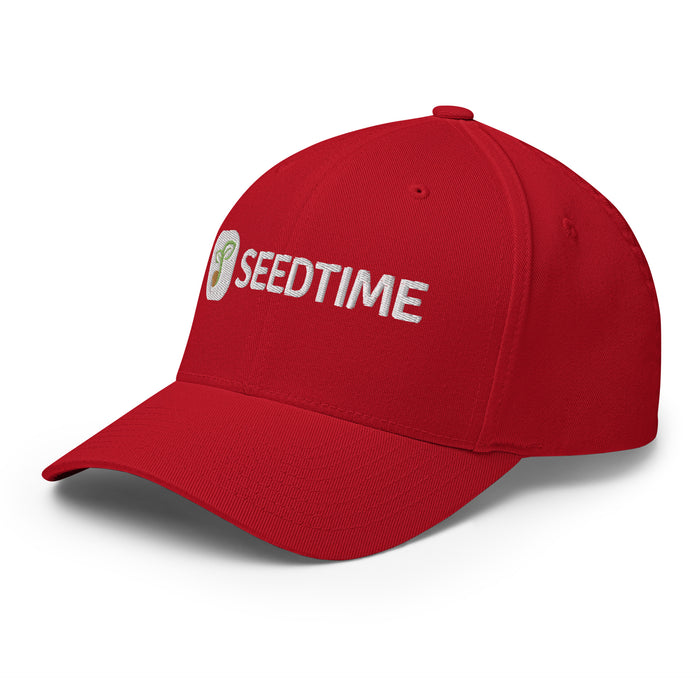 Red baseball cap with white embroidered Seedtime logo featuring a green sprout.