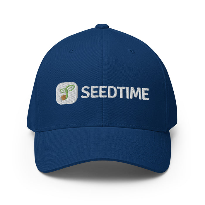 Navy blue Seedtime baseball cap with embroidered logo, white text, and green plant sprout icon.