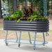 Mobile raised garden bed: dark gray corrugated metal planter with vibrant plants on a wheeled stand with shelf.
