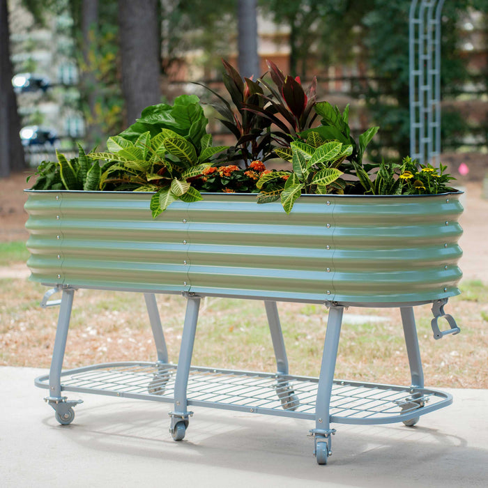 Mobile sage green corrugated metal raised garden bed with storage shelf and vibrant plants.