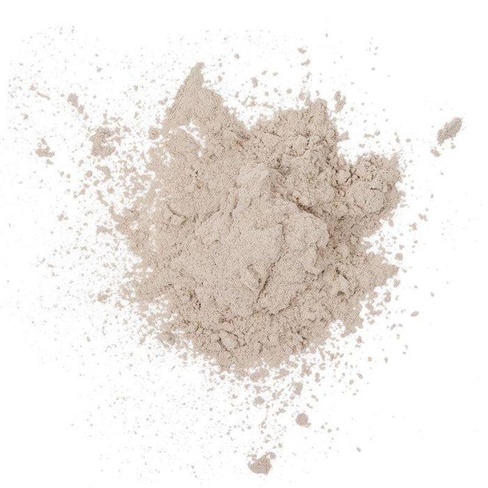 Loose beige face powder, finely milled, scattered texture.