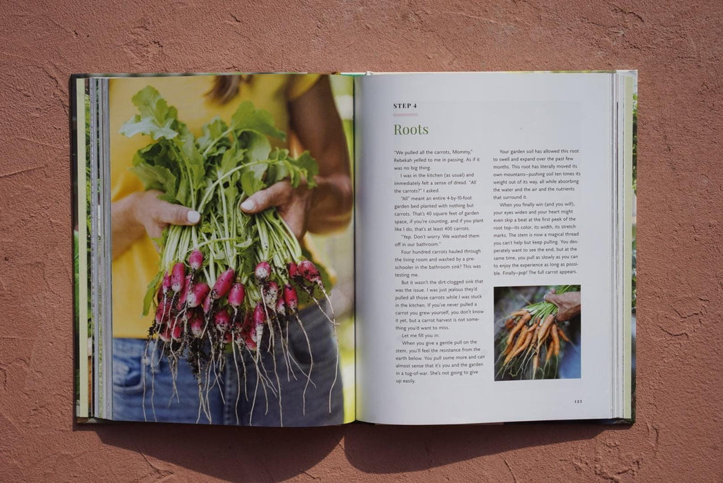 Open cookbook. Left: Hands hold a large bunch of freshly harvested radishes with green tops & soil. Right: "Roots" text & carrots.