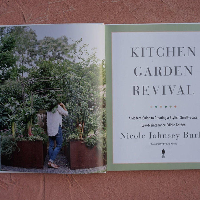 Kitchen Garden Revival book: woman tending a stylish, small-scale edible garden with raised beds. Modern gardening guide.