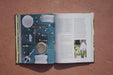 Flat lay of home gardening tools, salad spinner, seeds, and harvest bowl on a book page. Woman harvests fresh lettuce.