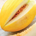 Fresh ripe yellow canary melon sliced in half, showing sweet white flesh and orange seeds. Delicious healthy fruit.