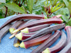 Freshly harvested red okra pods on blue fabric. Vibrant organic vegetables from the garden.