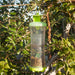 Effective green & clear fly and wasp trap in garden, full of caught insects. Outdoor pest control.