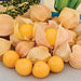 Fresh ground cherries and golden berries, some with papery husks, others showing vibrant yellow fruit.