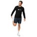 Man in black Seedtime long-sleeve shirt & dark shorts stretching quad. White socks & sneakers. Men's fitness activewear.