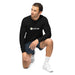 Man kneeling in black Seedtime long-sleeve shirt, dark shorts, and white sneakers. Casual athletic wear.