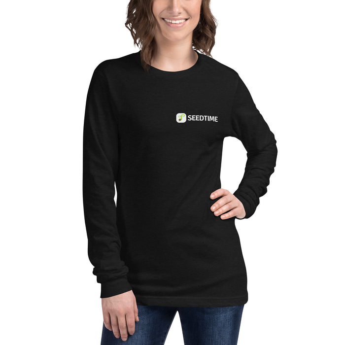 Smiling woman in black long-sleeve Seedtime t-shirt, featuring white text logo and green sprout icon.