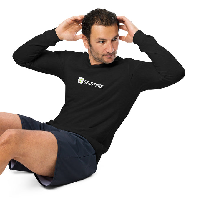 Man doing crunches in a black Seedtime long-sleeve shirt and dark athletic shorts. Exercise, fitness apparel.