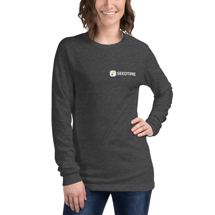 Smiling woman wears dark grey Seedtime long-sleeve t-shirt with green sprout logo.