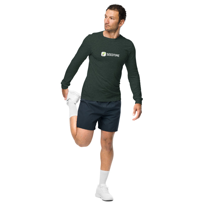 Man in Seedtime dark green long-sleeve shirt and navy shorts stretching. Athletic apparel for fitness.