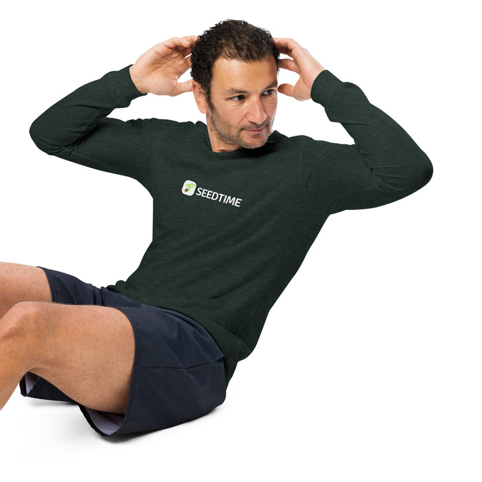 Man doing sit-ups in dark green Seedtime long-sleeve shirt and shorts. Fitness, workout, activewear.