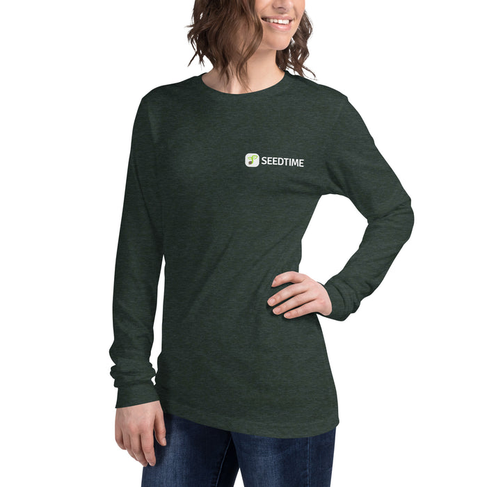 Smiling woman wears a heather forest Seedtime long-sleeve t-shirt with a plant logo. Comfortable women's garden apparel.