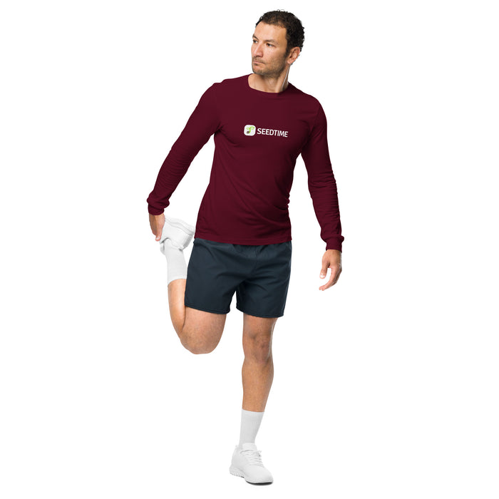 Athlete in maroon SEEDTIME long-sleeve shirt & black shorts performing quad stretch. Active fitness apparel.