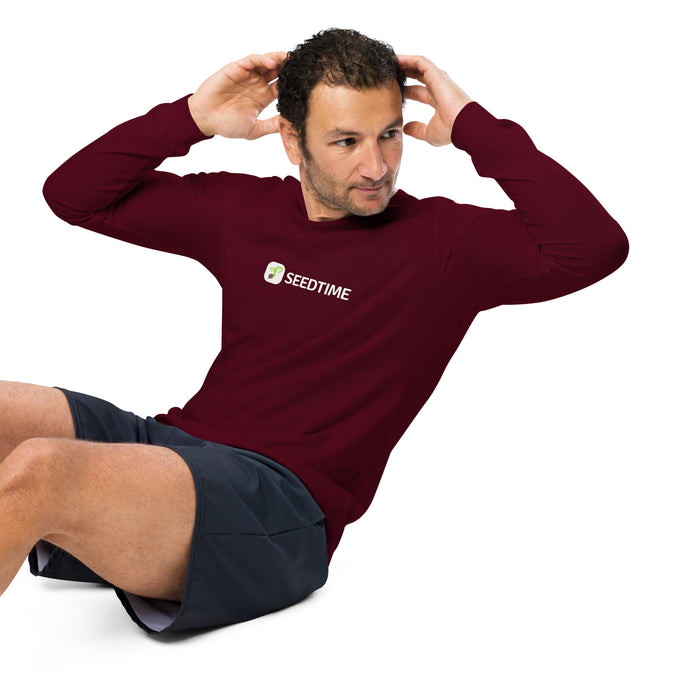 alt="Man doing crunches in maroon SEEDTIME long-sleeve shirt & dark grey shorts. Men's workout gear."