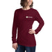 Smiling woman in a burgundy long-sleeve Seedtime logo t-shirt. Comfortable women's gardening apparel.