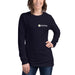 Smiling woman in navy blue Seedtime long-sleeve t-shirt with plant logo. Comfortable apparel for gardening enthusiasts.