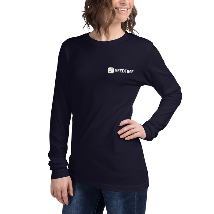 Smiling woman wears a navy long-sleeve Seedtime t-shirt with plant logo. Comfortable women's gardening apparel.