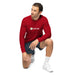 Man wearing red long-sleeve Seedtime logo shirt, athletic shorts, and white sneakers, kneeling.