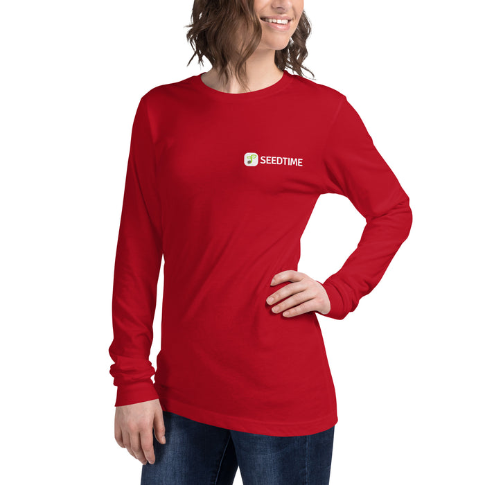 Smiling woman in red long-sleeve Seedtime t-shirt with sprout logo. Comfortable women's gardening apparel.