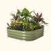 Sage green corrugated metal raised garden bed filled with tropical plants, yellow & orange flowers, and snake plant.