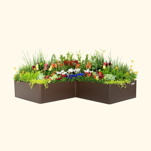 L-shaped dark brown raised garden bed with vibrant colorful flowers and green plants. Features 'vegi garden' label.