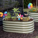 Backyard with two sage green corrugated steel raised garden beds, vibrant plants, orange flowers, and colorful pinwheels.