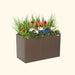 Brown Vega Garden planter box with vibrant white, blue, orange, and red flowers and tall green grasses. Ideal for patio decor.