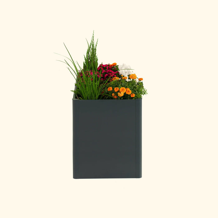 Modern dark gray planter box with vibrant pink, orange, white flowers, and diverse green plants.