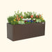 Long brown Vego Garden metal planter box with colorful flowers, herbs, and ornamental cabbage. Perfect for a raised garden bed.