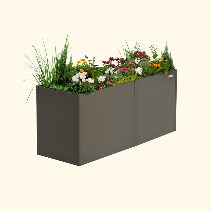 Vego Garden charcoal planter with white, orange, pink flowers, green plants & shrubs. Modern outdoor garden box.