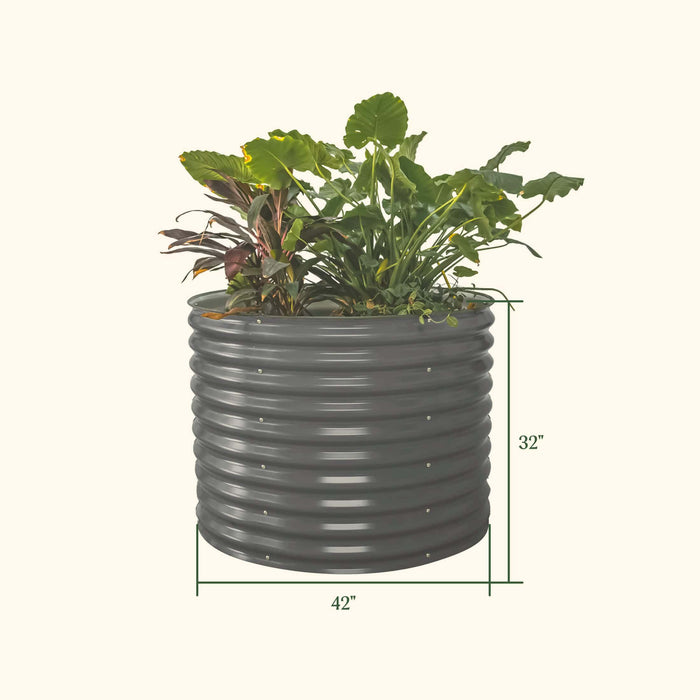 Round dark grey corrugated steel raised garden bed with plants, 32" tall x 42" wide. Ideal for backyard gardening.