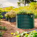 Green corrugated metal raised garden bed with herbs & solar light. Dark grey beds, wood mulch. Ideal for backyard container gardening.