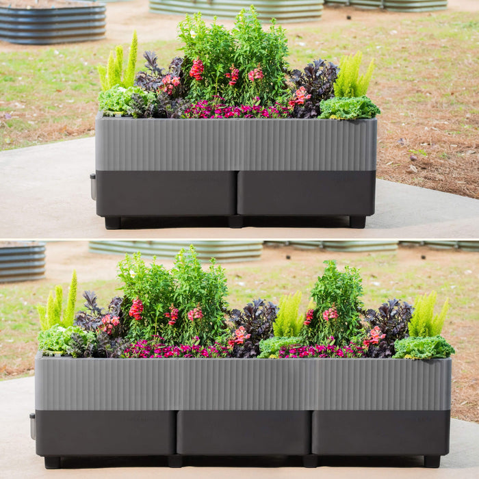 Vego Garden two-tone gray planter box with ribbed design, filled with colorful flowers and diverse green plants.