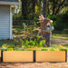 Man watering vibrant flowers and plants in a modern wood-look raised garden bed, ideal for backyard gardening.