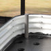 White corrugated metal raised garden bed interior with a support post and perforated self-watering base.