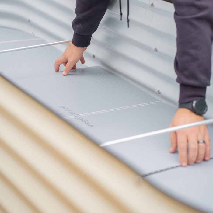 Installing Vego Garden self-watering liner mats into a corrugated metal raised garden bed.