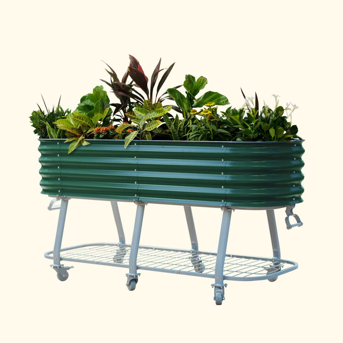 Green corrugated metal raised garden bed on wheels, with a lower storage shelf, planted with various flowers & foliage.
