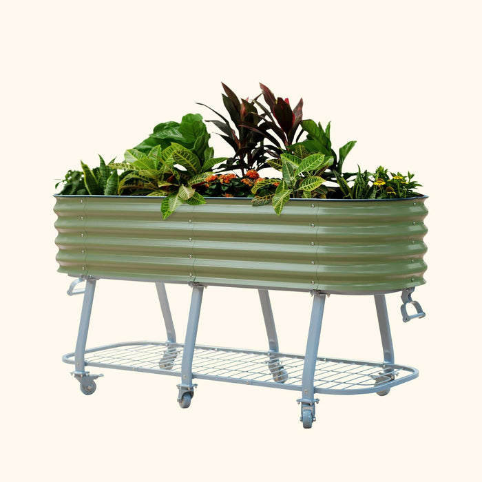 Olive green corrugated metal mobile raised garden bed with plants, on a grey stand with wheels and a lower shelf.