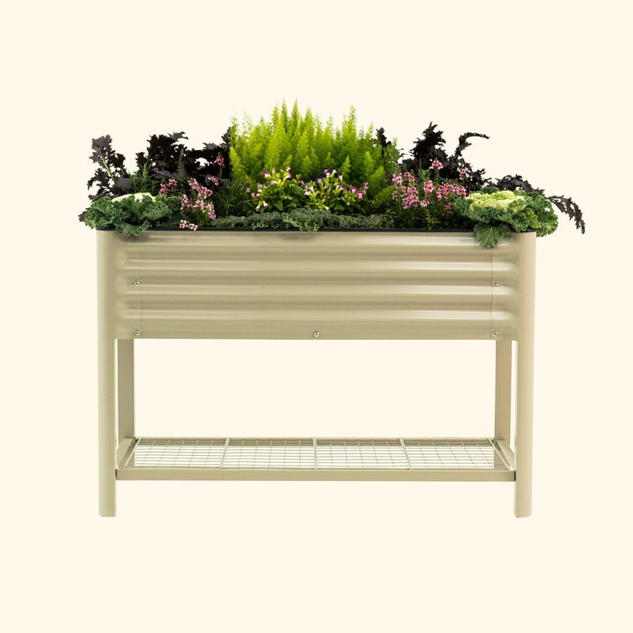 Beige corrugated metal raised garden bed with shelf, filled with kale, pink flowers, and ferns. Perfect for patio gardening.