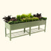 Sage green corrugated metal elevated garden bed with diverse plants, flowers, and a wire storage shelf.