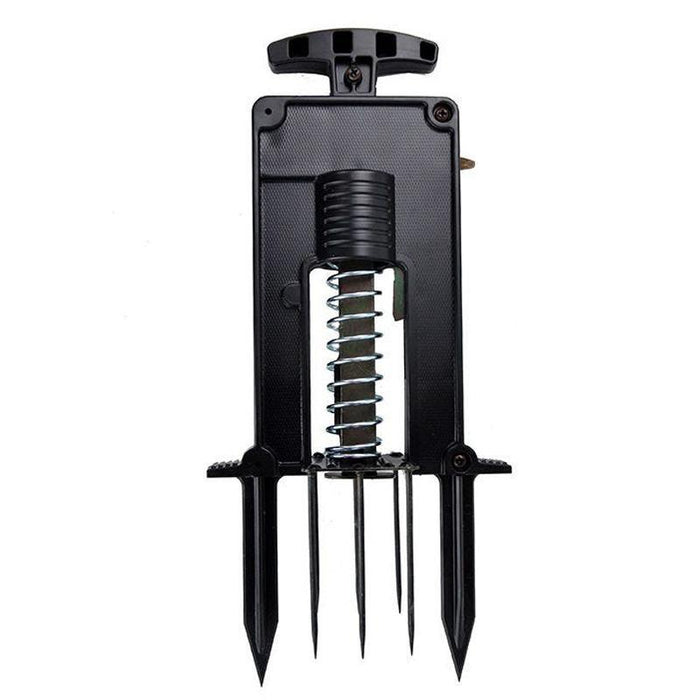 Black spring-loaded dibber for gardening. Features T-handle and five soil spikes for efficient planting.